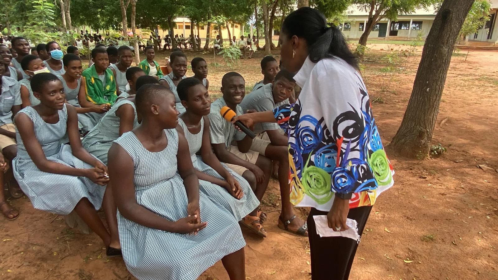 A facilitator speaking with students during an outdoor school gathering