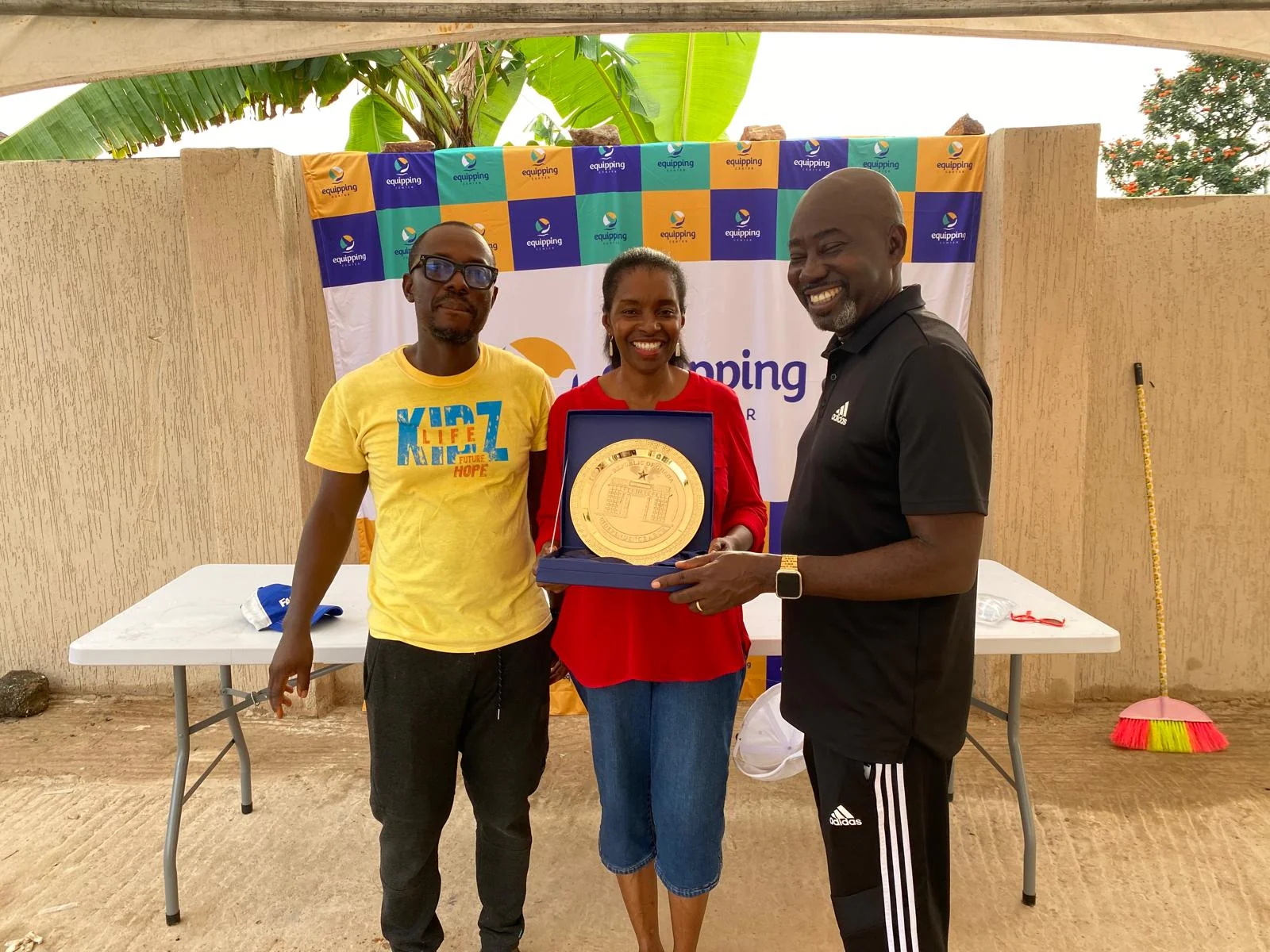 Equipping Center representatives presenting an award plaque