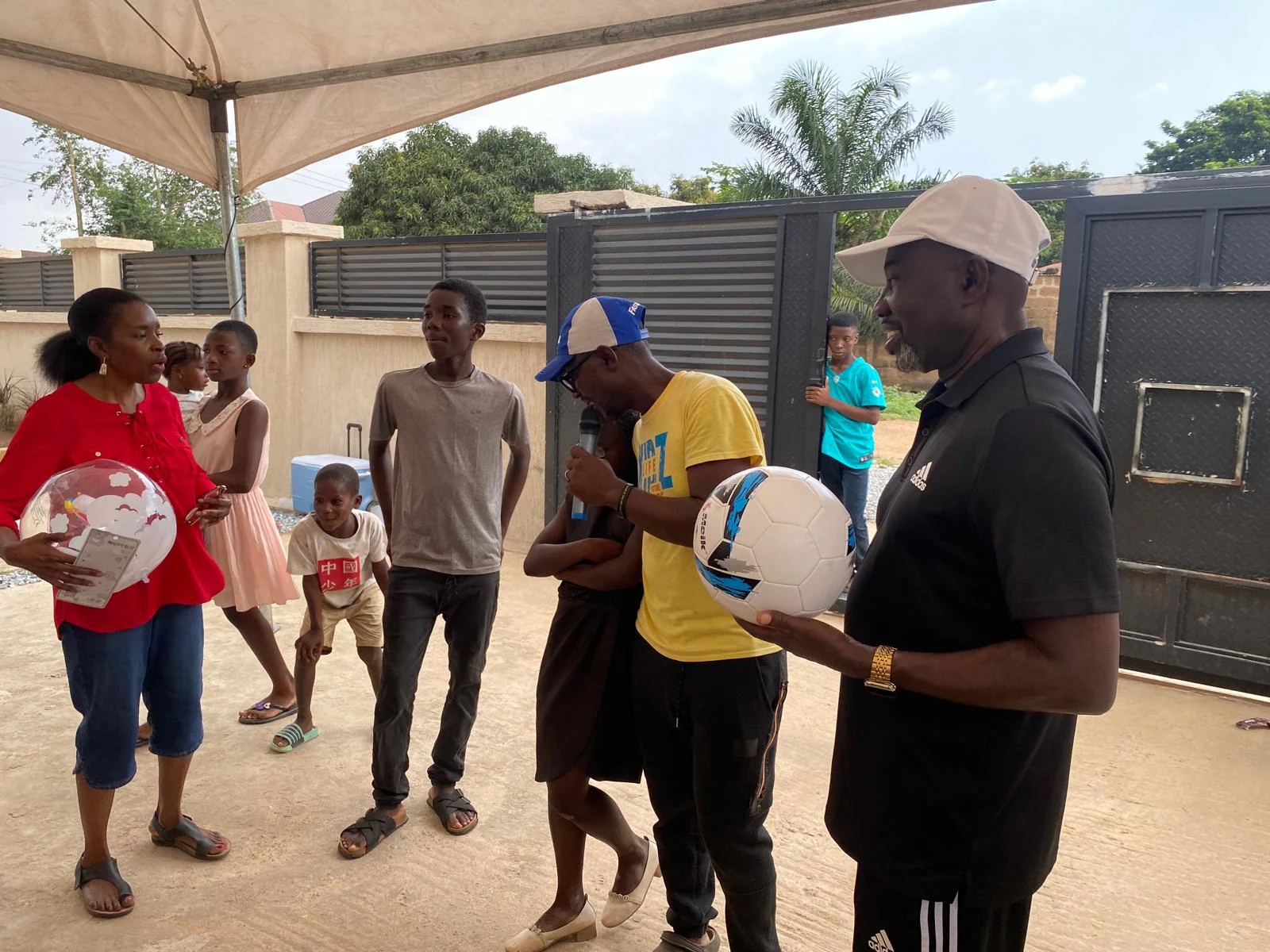 Community leaders presenting footballs during an outreach event